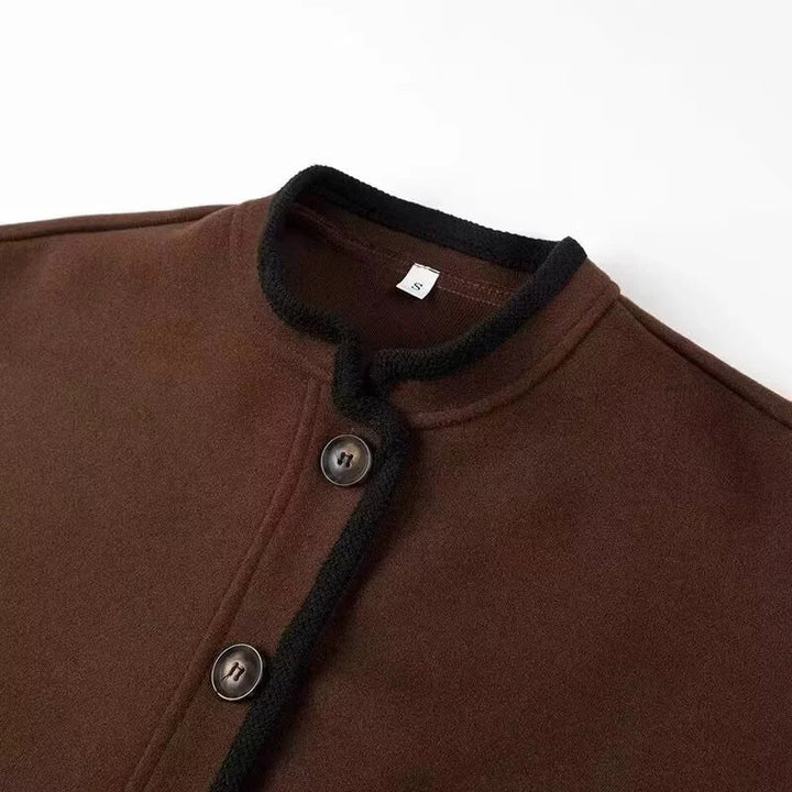 Dam cropped boxy jacka med liten ståkrage, kontrasterande piping, och welt fickor