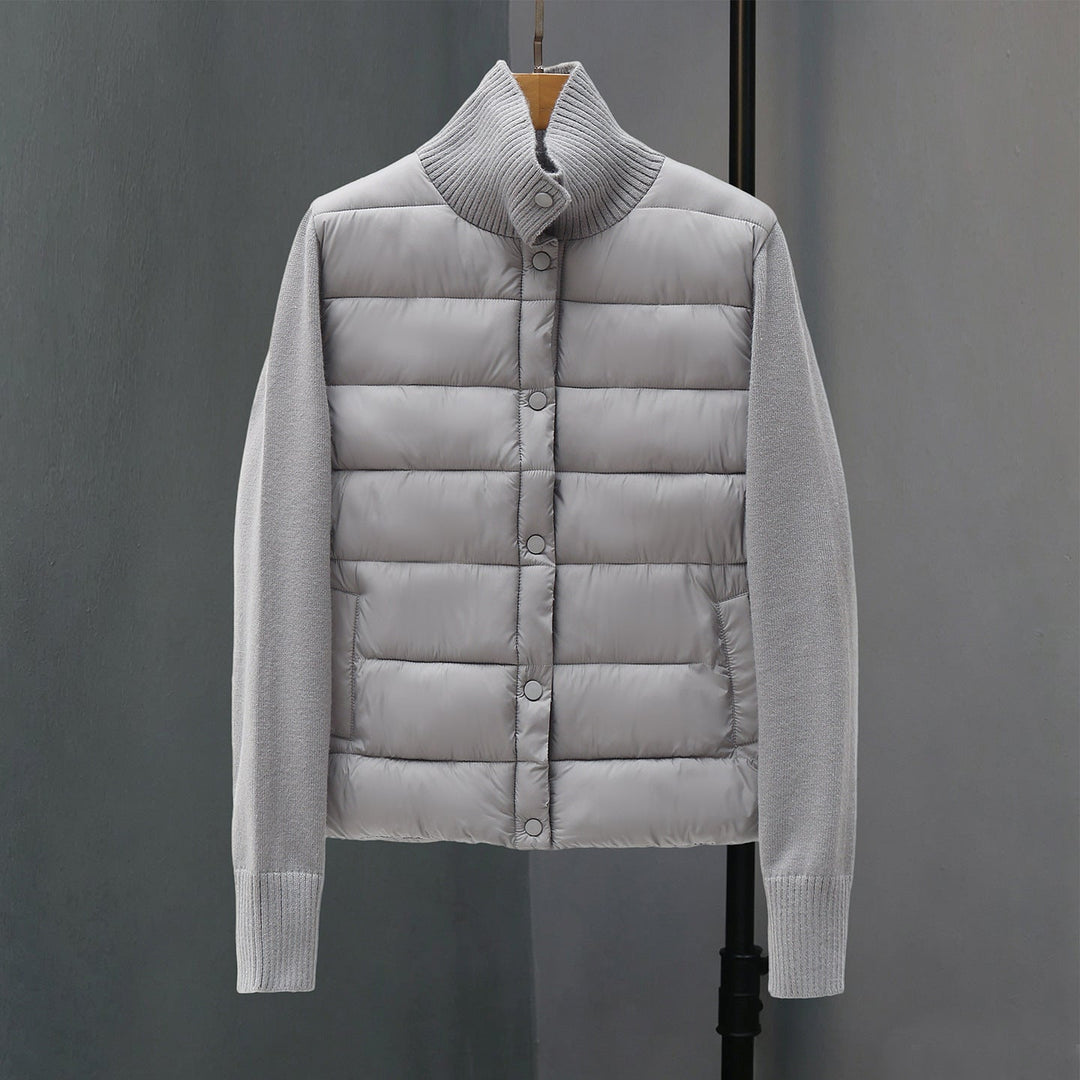 Dam quiltad hybrid jacka med vadderad front, fine stickad ärmar, och high ribbed krage