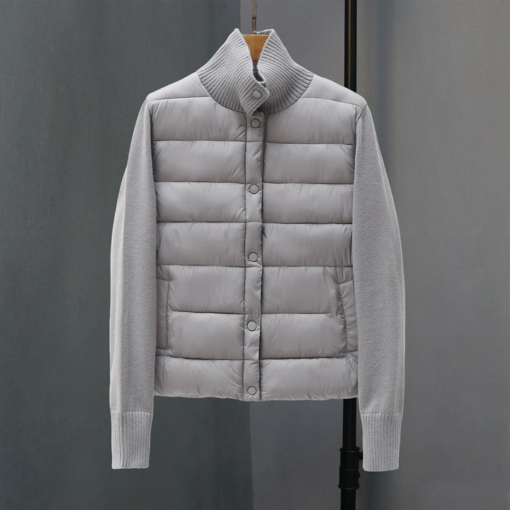 Dam quiltad hybrid jacka med vadderad front, fine stickad ärmar, och high ribbed krage