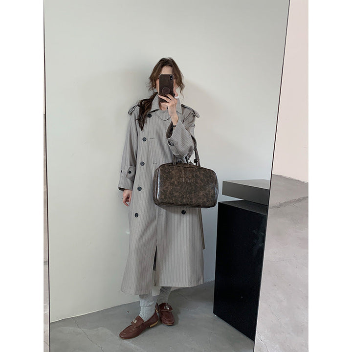 Dam pinstripe trenchcoat med boxy silhuett, shoulder patches, och dold knytband