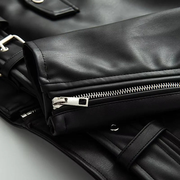 Dam asymmetrical bikerjacka tillverkad av vegan läder imitation med axel flaps, multiple fickor med dragkedja, och adjustable bälte