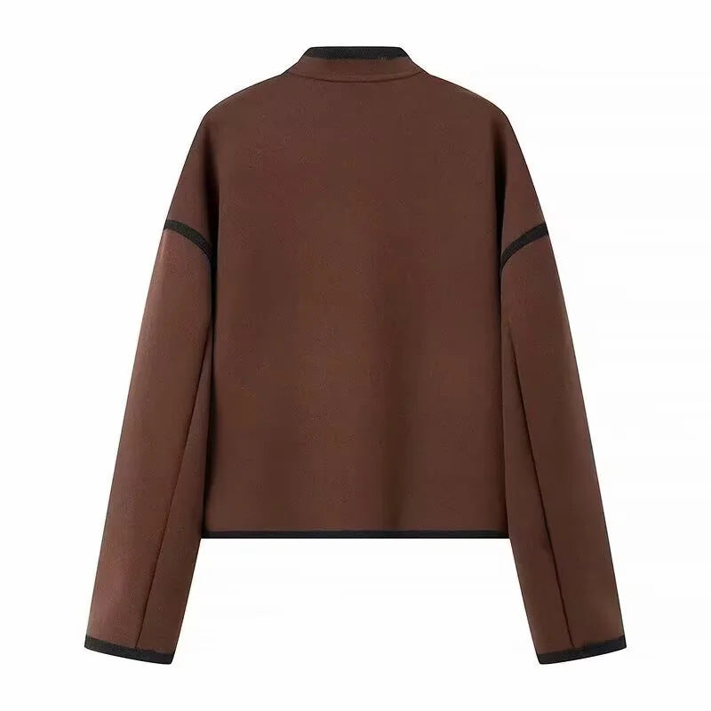 Dam cropped boxy jacka med liten ståkrage, kontrasterande piping, och welt fickor