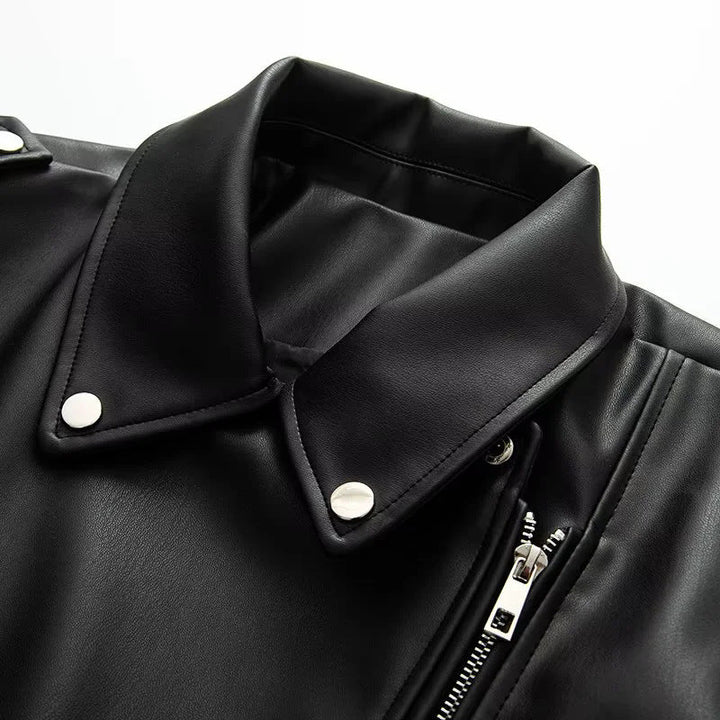 Dam asymmetrical bikerjacka tillverkad av vegan läder imitation med axel flaps, multiple fickor med dragkedja, och adjustable bälte