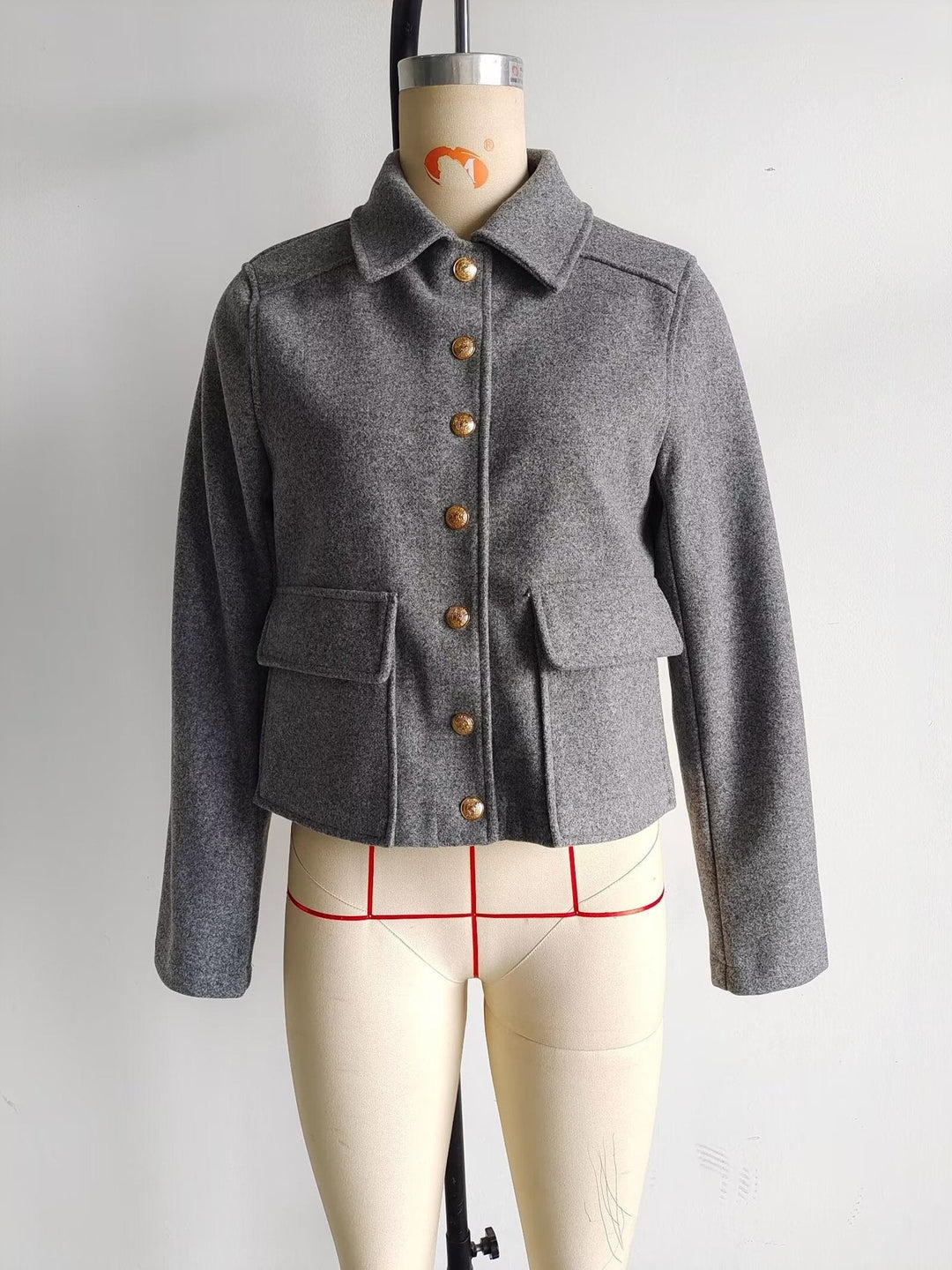 Dam kort ulljacka med gold button front, patch flap fickor, och figursydd silhuett