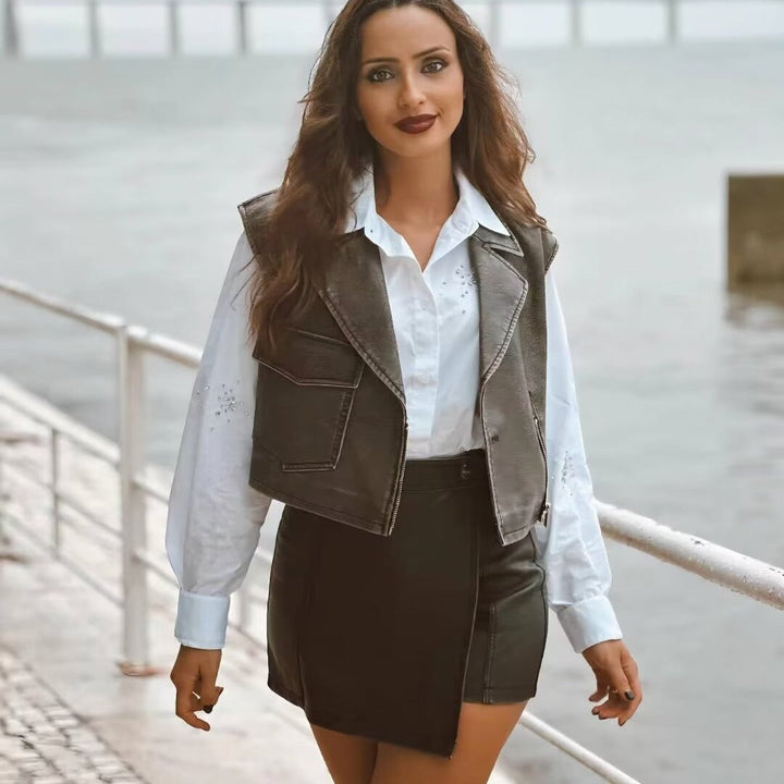 Dam kort sleeveless biker väst tillverkad av konstläder med bred lapels och asymmetric dragkedja