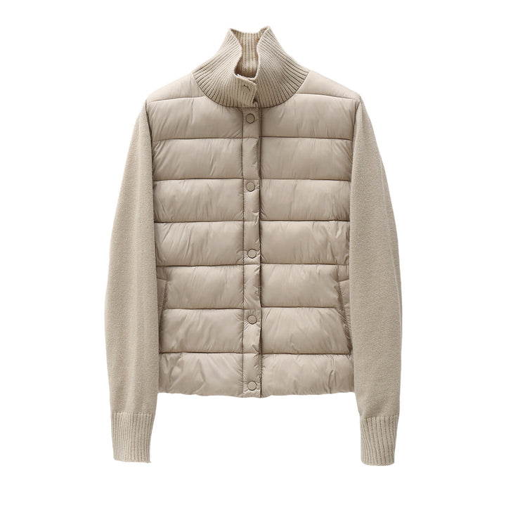 Dam quiltad hybrid jacka med vadderad front, fine stickad ärmar, och high ribbed krage