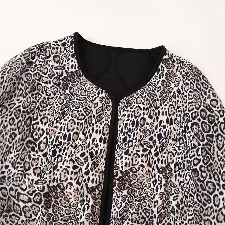 Dam quiltad kort jacka med leopardprint, open round neckline, kontrast piping, och påsydda fickor