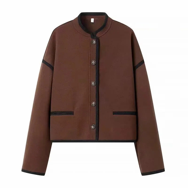 Dam cropped boxy jacka med liten ståkrage, kontrasterande piping, och welt fickor