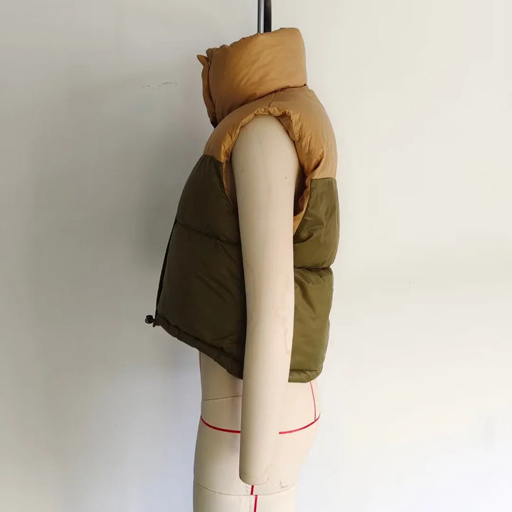 Dam sleeveless quiltad kort väst med high ståkrage, vadderad insulation, och adjustable drawstring fåll